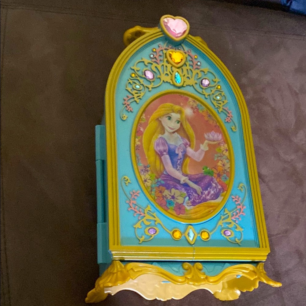 A rapunzal jewelry box main color blue with gold accents and jewel details.